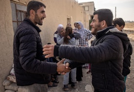 DAMASCUS, SYRIA - DECEMBER 21: Ahmed Muhammad Al-Nawa (L) is greeted by a neighbourhood friend after returning home from Lebanon to his family’s home in the village of Harran for the first time in 10-years on December 21, 2024 in Damascus, Syria. 36-year-old Ahmed, was imprisoned and tortured by the regime for a year and half in the Mezzah Military Prison in 2012-2013, after his release, his wife and daughter were displaced from their home in the village of Harran, Eastern Ghouta, Damascus, during the Assad regime’s siege of the region in 2014. They fled to Lebanon where they have been living in a tent in the Hosh Al-Hareem camp for the past 10-years. Ahmed’s mother Umm Marwan stayed behind in Syria due to a heart condition that stopped her from travelling. While living in Lebanon, Ahmed and his wife had four more children that were born in Lebanon and have never meet their grandmother, other relatives or seen the family home. After the fall of the regime Ahmed decided to return home bringing all his possessions from Lebanon and giving his mother the chance to meet her grandchildren face to face for the first time. (Photo by Chris McGrath/Getty Images)