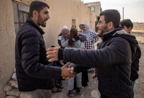 DAMASCUS, SYRIA - DECEMBER 21: Ahmed Muhammad Al-Nawa (L) is greeted by a neighbourhood friend after returning home from Lebanon to his family’s home in the village of Harran for the first time in 10-years on December 21, 2024 in Damascus, Syria. 36-year-old Ahmed, was imprisoned and tortured by the regime for a year and half in the Mezzah Military Prison in 2012-2013, after his release, his wife and daughter were displaced from their home in the village of Harran, Eastern Ghouta, Damascus, during the Assad regime’s siege of the region in 2014. They fled to Lebanon where they have been living in a tent in the Hosh Al-Hareem camp for the past 10-years. Ahmed’s mother Umm Marwan stayed behind in Syria due to a heart condition that stopped her from travelling. While living in Lebanon, Ahmed and his wife had four more children that were born in Lebanon and have never meet their grandmother, other relatives or seen the family home. After the fall of the regime Ahmed decided to return home bringing all his possessions from Lebanon and giving his mother the chance to meet her grandchildren face to face for the first time. (Photo by Chris McGrath/Getty Images)