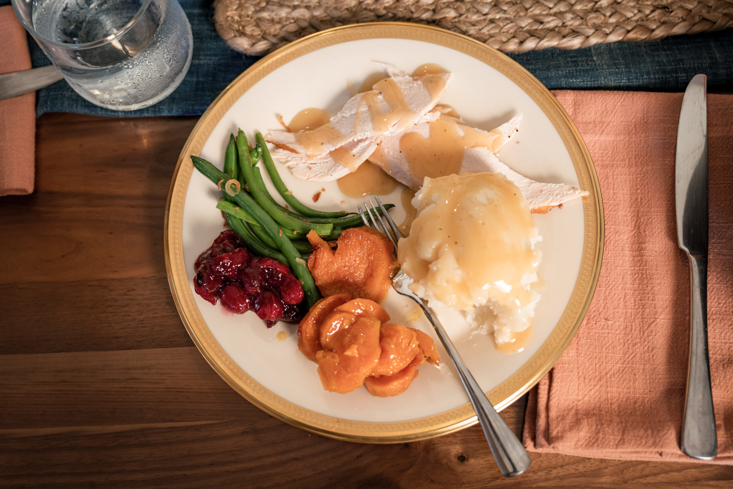 a black family gathers together to cook and eat a Thanksgiving meal.