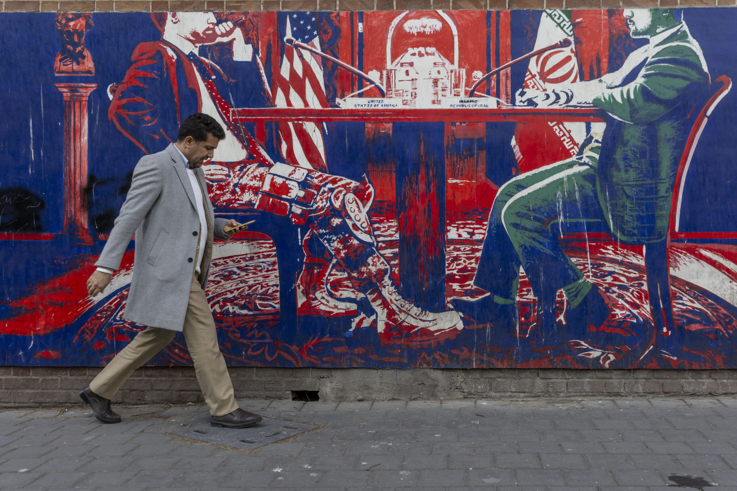 TEHRAN, IRAN - FEBRUARY 1: A man walks past a mural painted on the outer walls of the former US embassy in Tehran, colloquially-referred to as the Spy Den, on February 1, 2026. Iranian Supreme Leader Ayatollah Ali Khamenei today warned of ‘regional war’ if  the United States should attack Iran following heavy military deployments by Washington in the Gulf. (Photo by Majid Saeedi/Getty Images)