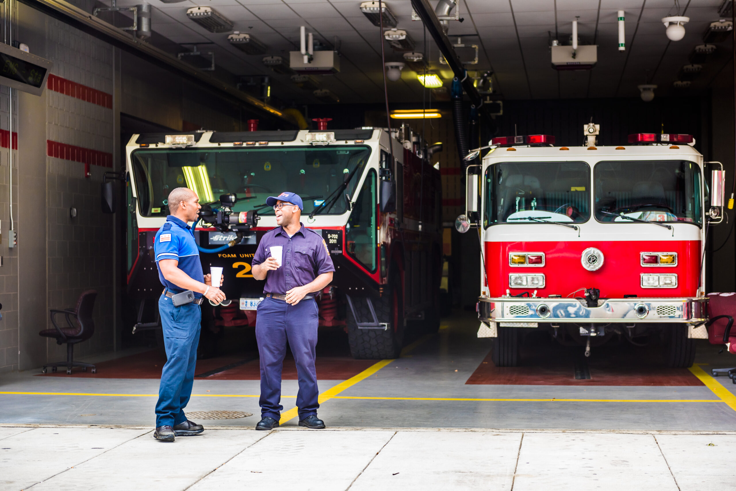 Washington Dc: Happy firefighters firemen smiling in downtown by trucks at fire station