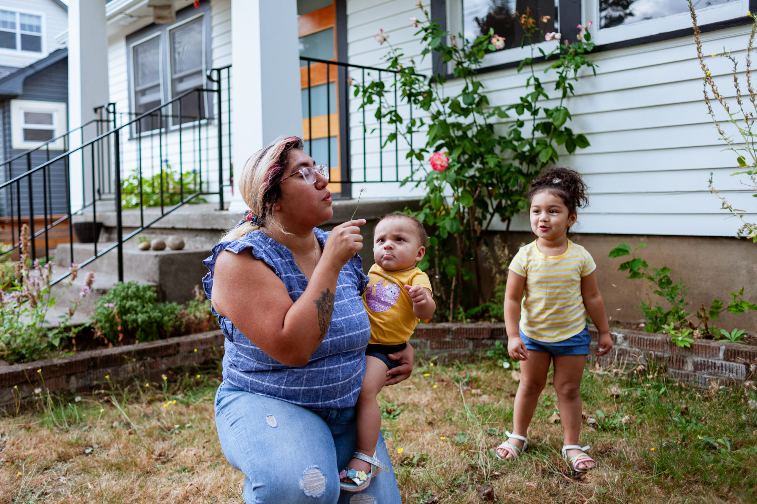 A multiracial latino/caucasian family with a single mom and two daughters having a fun time in the yard.