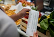 Close-up on a woman shopping at a supermarket and checking her receipt