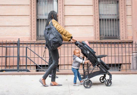 Young mother walking with infant daughter in the city